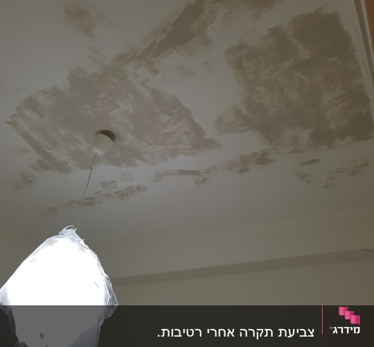 תקרה עם תיקוני צבע וטיח, מנורה מכוסה בניילון